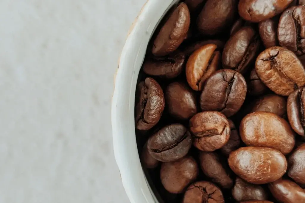 白いカップに入った、焙煎したコーヒー豆